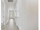 Bright hallway with light wood flooring and white walls, leading to a sunlit entryway at 11885 Richmond Trl, Parrish, FL 34219