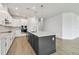 Modern kitchen featuring white cabinetry, stainless appliances, and a dark gray island with pendant lighting at 11885 Richmond Trl, Parrish, FL 34219