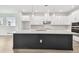 Modern kitchen with a large island, sleek white cabinets, and stainless steel appliances at 11885 Richmond Trl, Parrish, FL 34219
