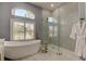 Bright bathroom featuring a modern soaking tub, elegant gold fixtures, and a glass-enclosed shower at 12110 Marblehead Dr, Tampa, FL 33626