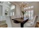 Charming dining room with shuttered windows, a rustic wooden table, and bright white chairs and walls at 12110 Marblehead Dr, Tampa, FL 33626