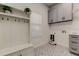 The modern laundry room features shaker style cabinets and decorative patterned tile at 12110 Marblehead Dr, Tampa, FL 33626