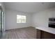 Bright living room with wood-look flooring, natural light, and modern kitchen features in the background at 14184 Hammock Crest Way, Riverview, FL 33569