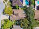 Aerial shot of a home showcasing the roof, well-kept yard, trees, and proximity to neighborhood pools and amenities at 1514 River Ct, Tarpon Springs, FL 34689