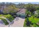 Aerial view of charming green home featuring a brick-paved driveway, lush lawn and mature trees at 1514 River Ct, Tarpon Springs, FL 34689