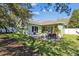 Expansive backyard with a covered patio, seating areas, and mature trees at 1514 River Ct, Tarpon Springs, FL 34689
