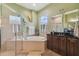 Bathroom featuring a glass-enclosed shower and a soaking tub, complemented by a stylish vanity and decor at 1514 River Ct, Tarpon Springs, FL 34689