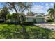Charming single-story home with a lush green lawn, inviting curb appeal, and a brick-paved driveway at 1514 River Ct, Tarpon Springs, FL 34689