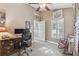 Bright home office with a ceiling fan, a desk, a comfortable chair, and plantation shutters for natural light at 1514 River Ct, Tarpon Springs, FL 34689