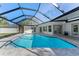 Swimming pool with screened enclosure, white exterior house, and manicured backyard at 1664 Sharon Way, Clearwater, FL 33764