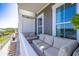 Comfortable outdoor balcony seating area with views of the waterfront and nearby buildings at 19915 Gulf Blvd # 704, Indian Shores, FL 33785