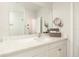 Bright bathroom featuring a sleek vanity, well-lit mirror, and a glimpse into a modern, glass-enclosed shower at 19915 Gulf Blvd # 704, Indian Shores, FL 33785