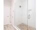 Bright bathroom featuring a glass-enclosed shower with pebble flooring and white subway tile at 19915 Gulf Blvd # 704, Indian Shores, FL 33785