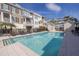 Inviting community pool area surrounded by lounge chairs, lush landscaping, and stylish townhomes at 19915 Gulf Blvd # 704, Indian Shores, FL 33785