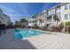 Stunning community pool area with lounge seating, attractive townhomes, and lush tropical landscaping at 19915 Gulf Blvd # 704, Indian Shores, FL 33785