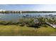 Scenic waterfront view of boat dock, green lawn, and neighboring residential buildings on a clear, sunny day at 19915 Gulf Blvd # 704, Indian Shores, FL 33785