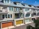 Townhome exteriors displaying modern architecture, private balconies, and colorful garages at 19915 Gulf Blvd # 704, Indian Shores, FL 33785