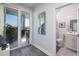 Bright hallway features sliding glass doors leading to a patio and a glimpse into a pristine bathroom at 19915 Gulf Blvd # 704, Indian Shores, FL 33785