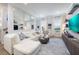 Bright living room featuring modern decor, a white leather sectional, and open windows at 19915 Gulf Blvd # 704, Indian Shores, FL 33785