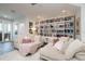 Spacious living room with plush sofas, a large bookshelf, and access to the balcony at 19915 Gulf Blvd # 704, Indian Shores, FL 33785