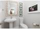 Tastefully designed powder room with a pedestal sink, decorative mirror, and modern fixtures at 19915 Gulf Blvd # 704, Indian Shores, FL 33785