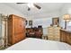 Bedroom with bed, armoire, desk and chair, with neutral colored carpet at 2459 Columbia Dr # 3, Clearwater, FL 33763