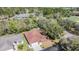 An aerial view shows a home with a clean driveway and yard surrounded by green trees in a serene community at 29443 Zeller Ave, San Antonio, FL 33576