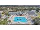 Aerial view of clubhouse, community pool with water feature, surrounded by lush landscaping at 29443 Zeller Ave, San Antonio, FL 33576