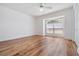 Bright bedroom with hard wood flooring, vaulted ceiling, and a large window at 29443 Zeller Ave, San Antonio, FL 33576