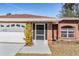 Charming brick home featuring a well-manicured lawn, attached garage, and a welcoming front entrance at 29443 Zeller Ave, San Antonio, FL 33576