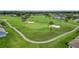 Scenic golf course with a sand trap, palm trees, and paved path at 29443 Zeller Ave, San Antonio, FL 33576