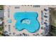 Aerial view of a uniquely shaped pool with surrounding lounge chairs and umbrellas at 29443 Zeller Ave, San Antonio, FL 33576