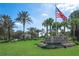 Entrance to Tampa Bay Golf & Country Club showcases palm trees, flower beds, and an American flag at 29443 Zeller Ave, San Antonio, FL 33576