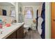 Bathroom featuring a single sink, vanity, window with curtains, and wood-look flooring at 303 Grand Ave, Brooksville, FL 34604