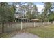 Charming green home with a cozy front porch and a quaint fenced yard at 303 Grand Ave, Brooksville, FL 34604