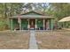 Charming green home with a cozy front porch and inviting swing at 303 Grand Ave, Brooksville, FL 34604