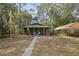 Inviting green home featuring a cozy covered porch and a well-maintained yard at 303 Grand Ave, Brooksville, FL 34604