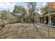 Landscaped front yard with mature trees, walkway, and charming green exterior at 303 Grand Ave, Brooksville, FL 34604
