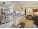 Open-concept kitchen with stainless appliances, granite countertops, wood floors, and an island, connecting to the living area at 303 Grand Ave, Brooksville, FL 34604