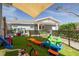 Playful backyard featuring well-maintained artificial turf, playful toys, and a covered patio area for Gathering fun at 305 6Th Sw Ave, Largo, FL 33770