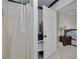 Bathroom featuring a shower, stacked washer/dryer, a laundry basket, and access to the main bedroom at 305 6Th Sw Ave, Largo, FL 33770