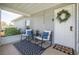 Inviting front porch features seating, a welcome mat, and a decorative wreath on the white front door at 305 6Th Sw Ave, Largo, FL 33770