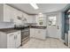 Bright kitchen features white cabinets, stainless steel appliances, tile backsplash, and backyard access at 305 6Th Sw Ave, Largo, FL 33770