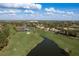 Expansive aerial showcasing a residential area alongside a golf course, ponds and trees at 3130 Eagles Landing W Cir, Clearwater, FL 33761