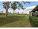 Backyard view of home overlooking lush green landscaping and a beautiful golf course with mature trees at 3130 Eagles Landing W Cir, Clearwater, FL 33761
