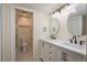 Bathroom featuring double sinks, modern fixtures, and a walk-in shower at 3130 Eagles Landing W Cir, Clearwater, FL 33761