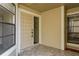 Covered front porch of the home with tile floors and a view of the front door at 3130 Eagles Landing W Cir, Clearwater, FL 33761