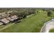 Aerial view of homes bordering a well-manicured golf course with mature trees and a water hazard at 3130 Eagles Landing W Cir, Clearwater, FL 33761