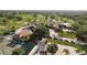 An aerial view shows a golf course clubhouse, parking, tennis courts, and manicured green space at 3130 Eagles Landing W Cir, Clearwater, FL 33761