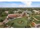 Aerial image features a golf course with clubhouse, tennis courts, and meticulously landscaped grounds, bordered by trees at 3130 Eagles Landing W Cir, Clearwater, FL 33761